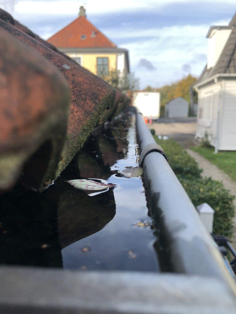 Star City Pro Wash team member expertly and carefully removing debris from a clogged gutter in Roanoke, VA.